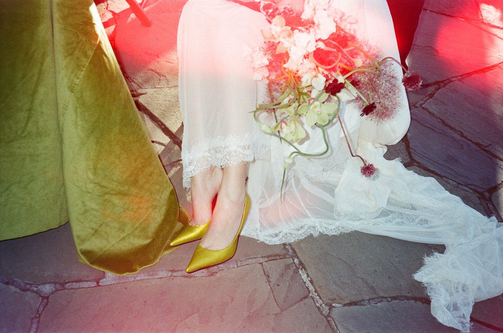 Film photograph of a bride's lime green shoes with red light leaks taken by Oregon wedding photographer, Briana Morrison