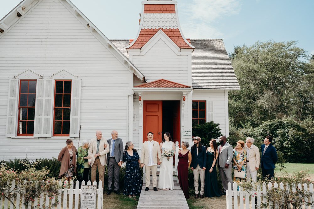 A family stands in front of the church for a candid group photo. Photographed by Oregon wedding photographer, Briana Morrison.