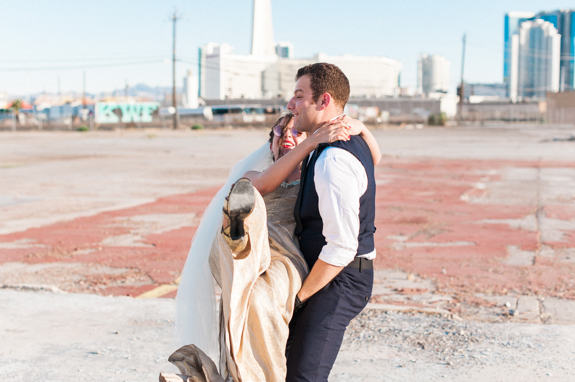 A groom carries his bride in Las Vegas, Nevada. Captured by Las Vegas Elopement Photographer Briana Morrison