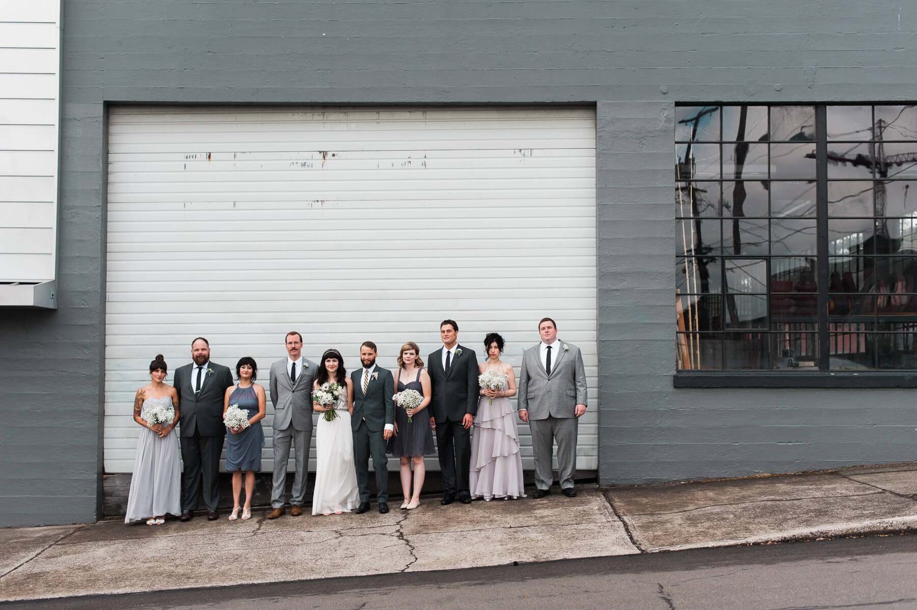 A bridal party poses in industrial Portland, Oregon. By Portland Holocene Wedding Photographer Briana Morrison