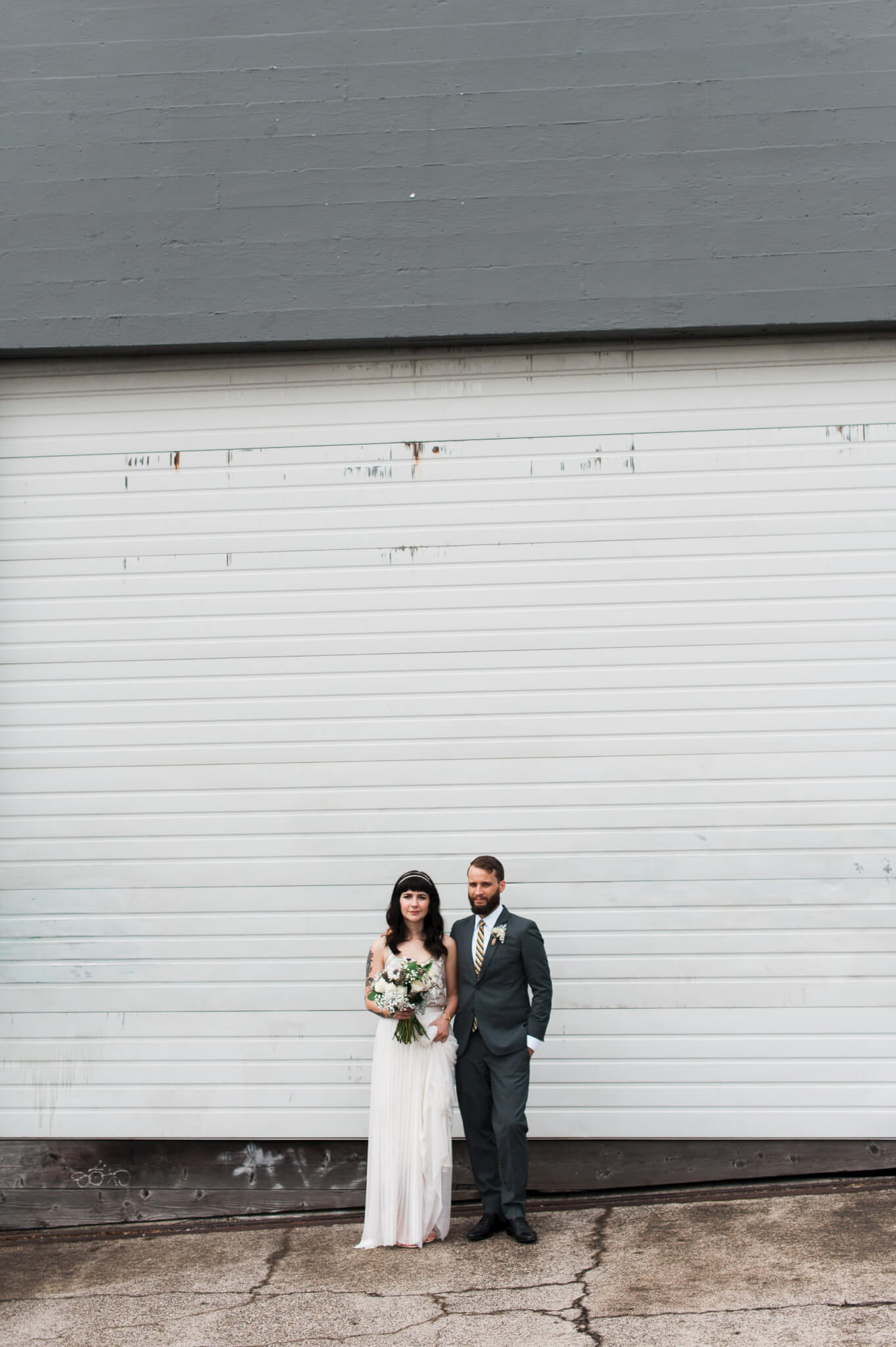 A hip bride and groom pose after their wedding at Holocene in Portland, Oregon.