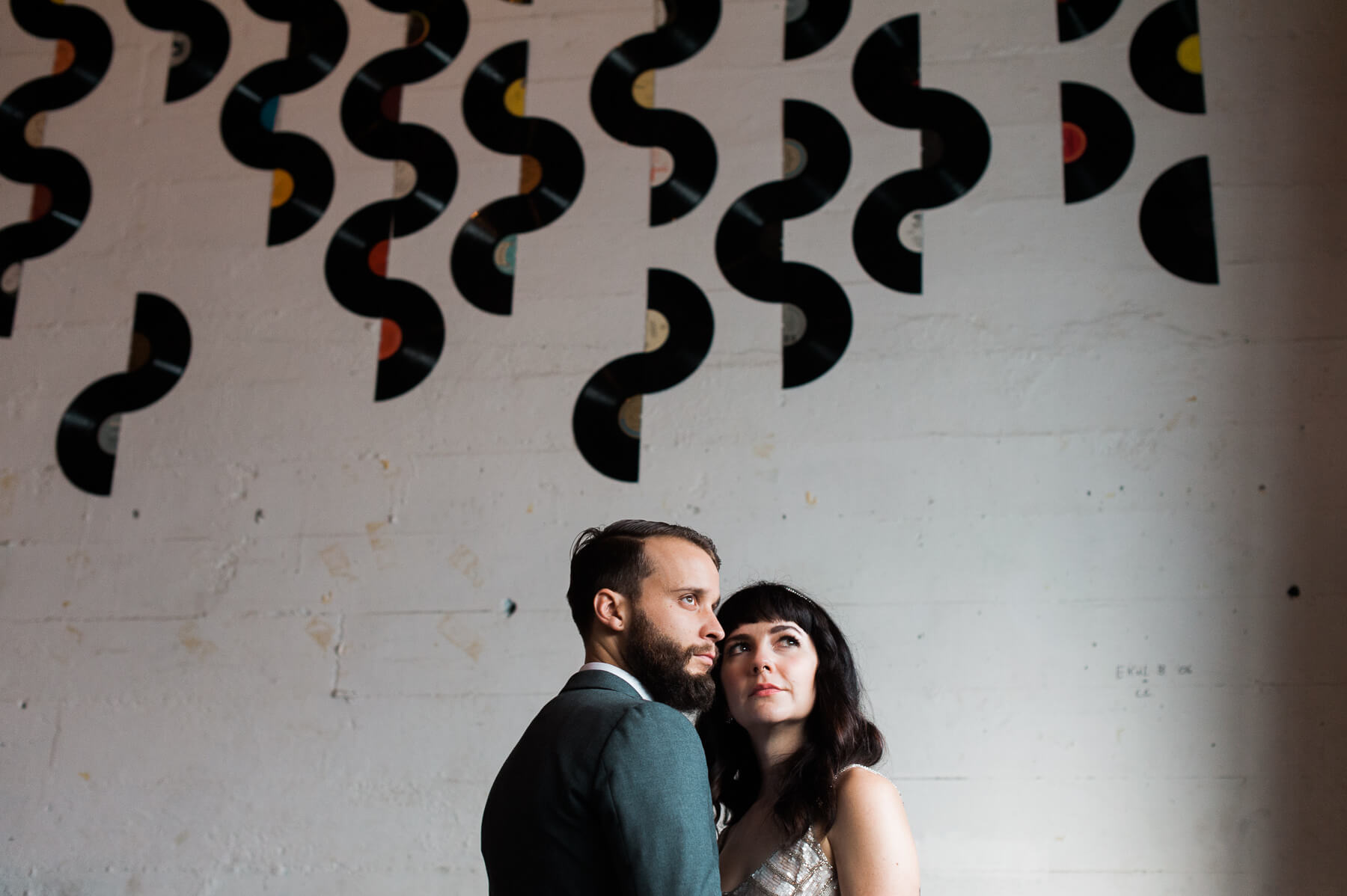 A bride and groom pose in one of Portland Holocene's getting ready rooms. Holocene Wedding Photography by Briana Morrison