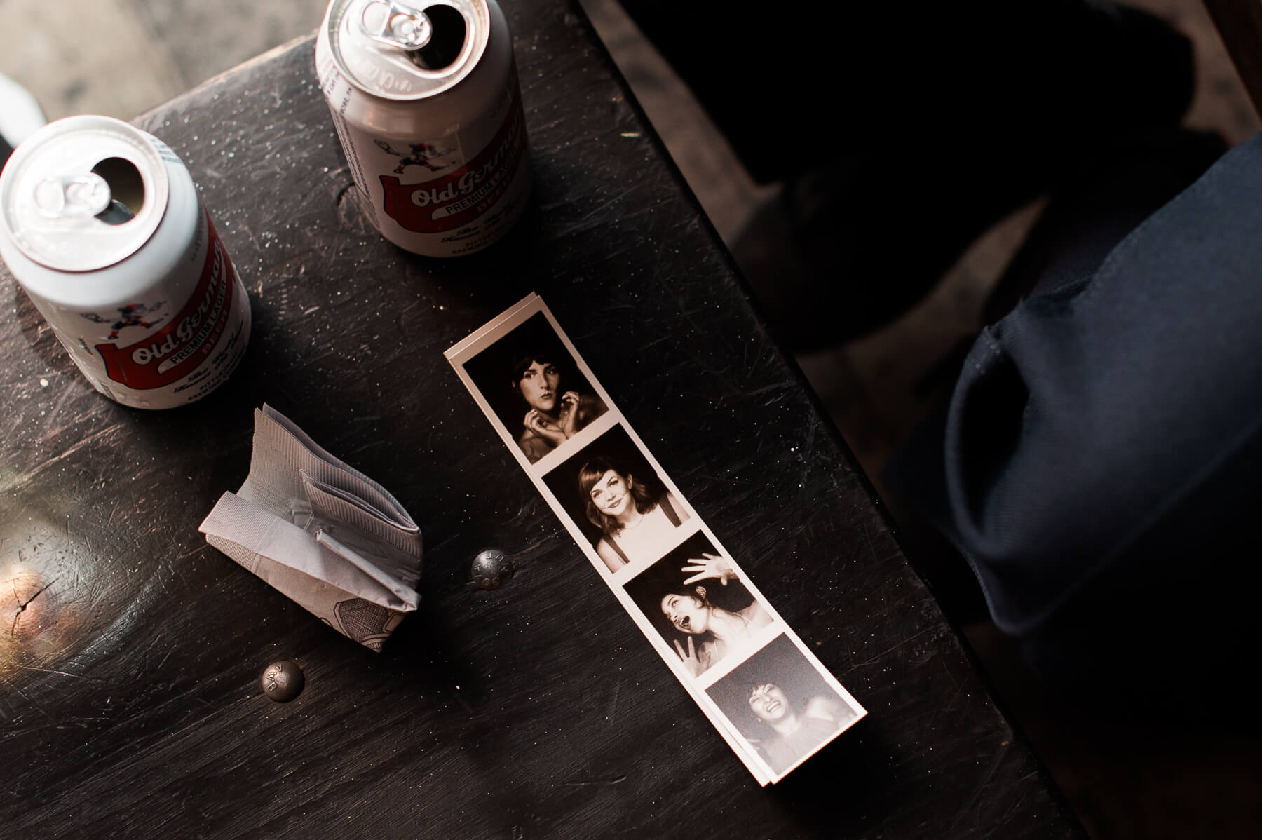Photo booth strips and empty beer cans at a wedding in Portland, Oregon. By Portland Holocene Wedding Photographer Briana Morrison