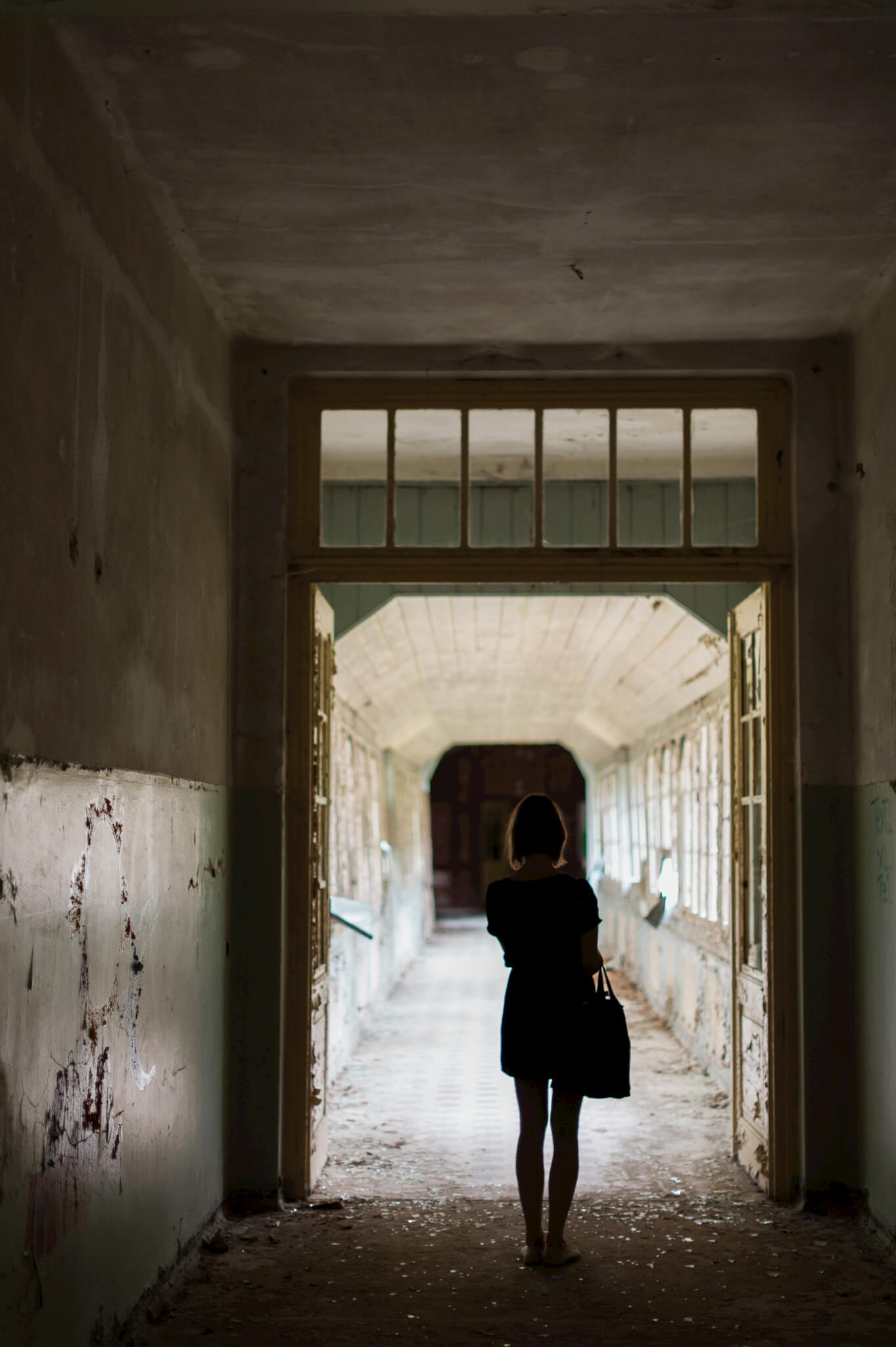 Portrait of a woman inside the decaying interior of Heilstätten Hohenlychen Sanatorium in Lychen, Germany. Photographs by Berlin Portrait Photographer Briana Morrison