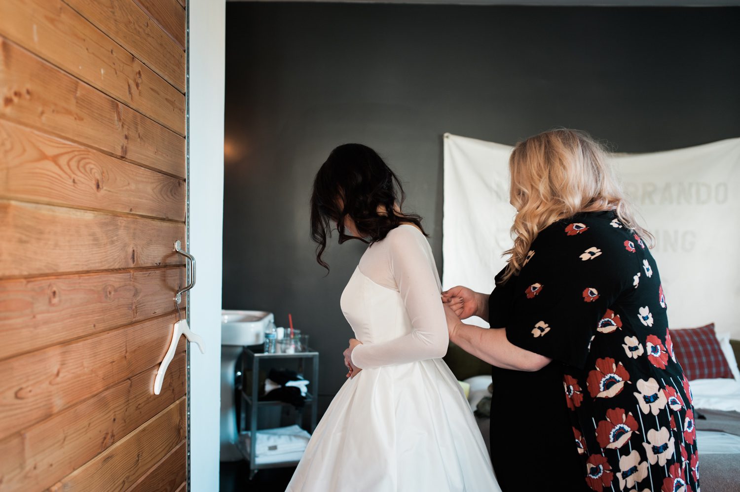 The bride putting on her dress. by Ace Hotel wedding photographer Briana Morrison