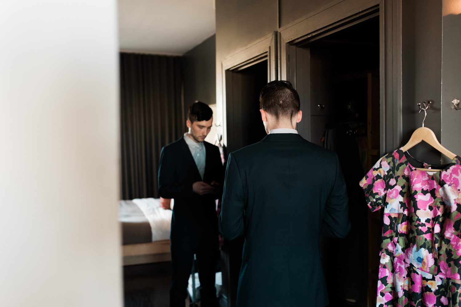 The groom getting ready and texting his bride. By Ace Hotel wedding photographer Briana Morrison