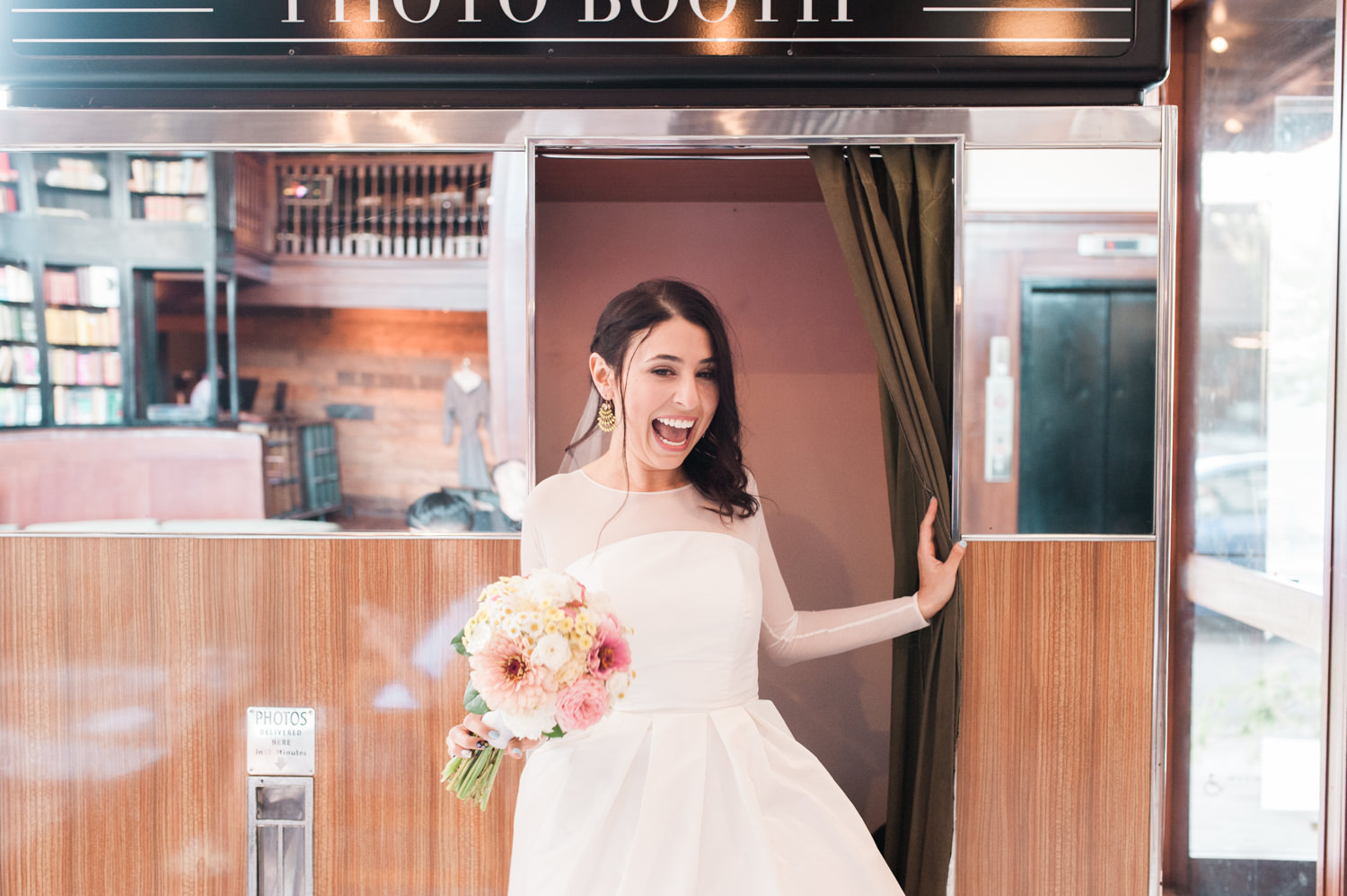 A super happy bride exits the photo booth at Ace Hotel Portland. by Ace Hotel wedding photographer Briana Morrison