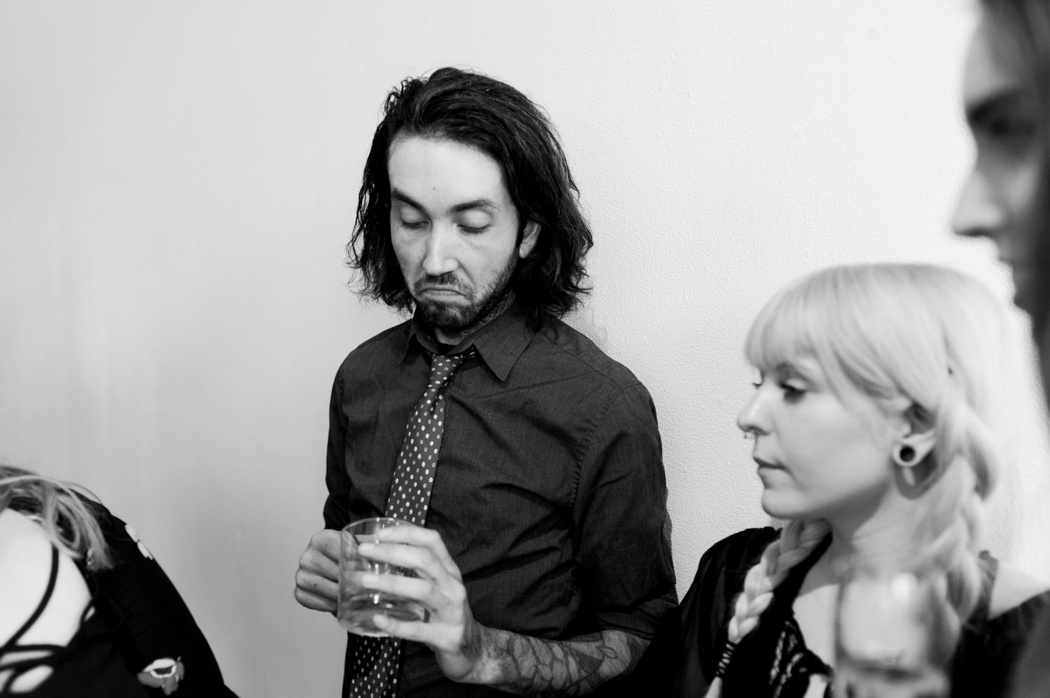 A wedding guests looks askance at his drink by Ace Hotel wedding photographer Briana Morrison