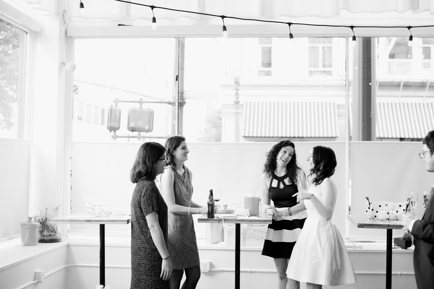 Black and white portrait of the bride chatting with guests. by The Cleaners wedding photographer Briana Morrison