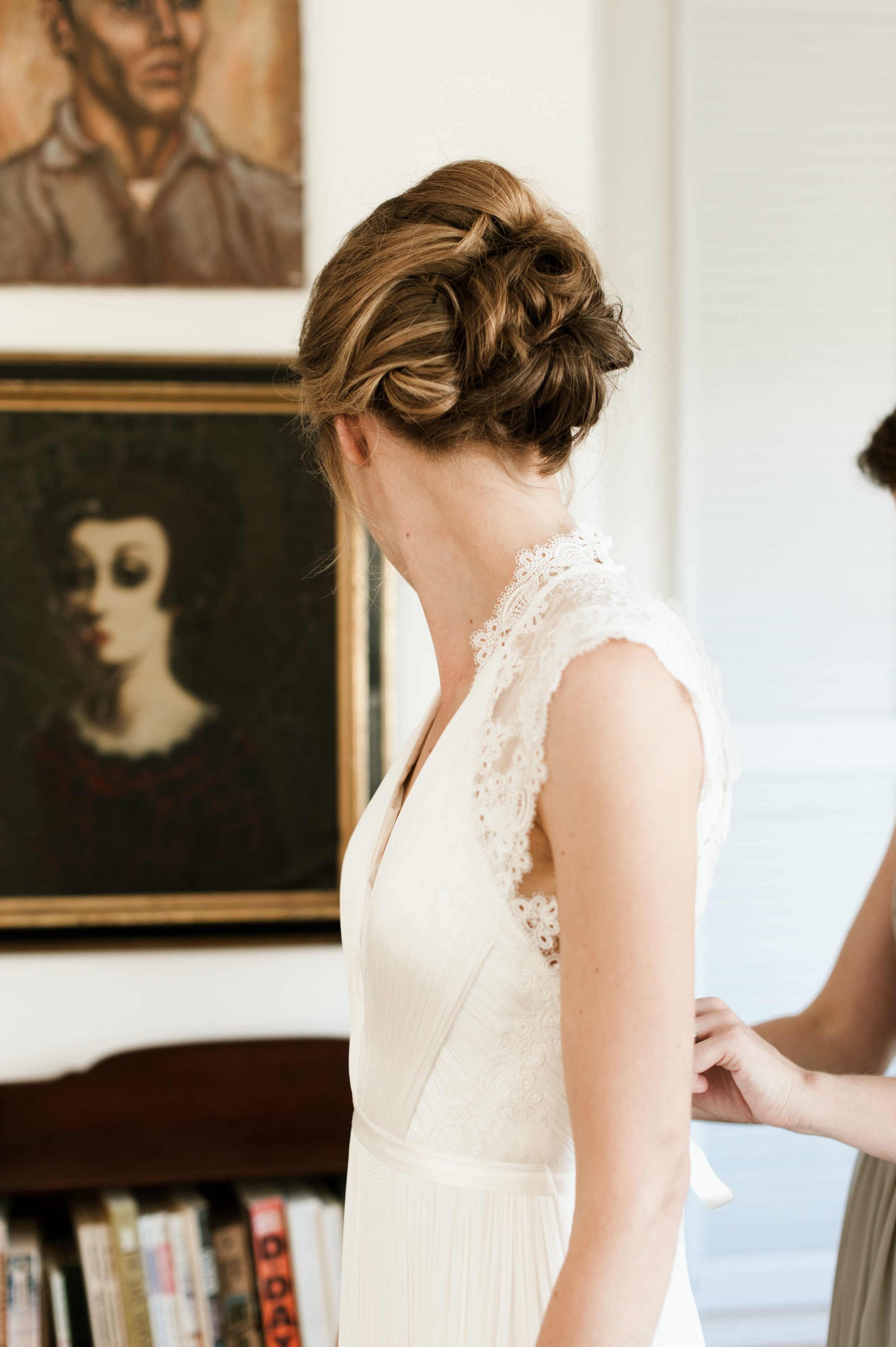 The bride gets help putting on her dress at the Portland Mayor's Mansion. By Laurelhurst Park wedding photographer Briana Morrison
