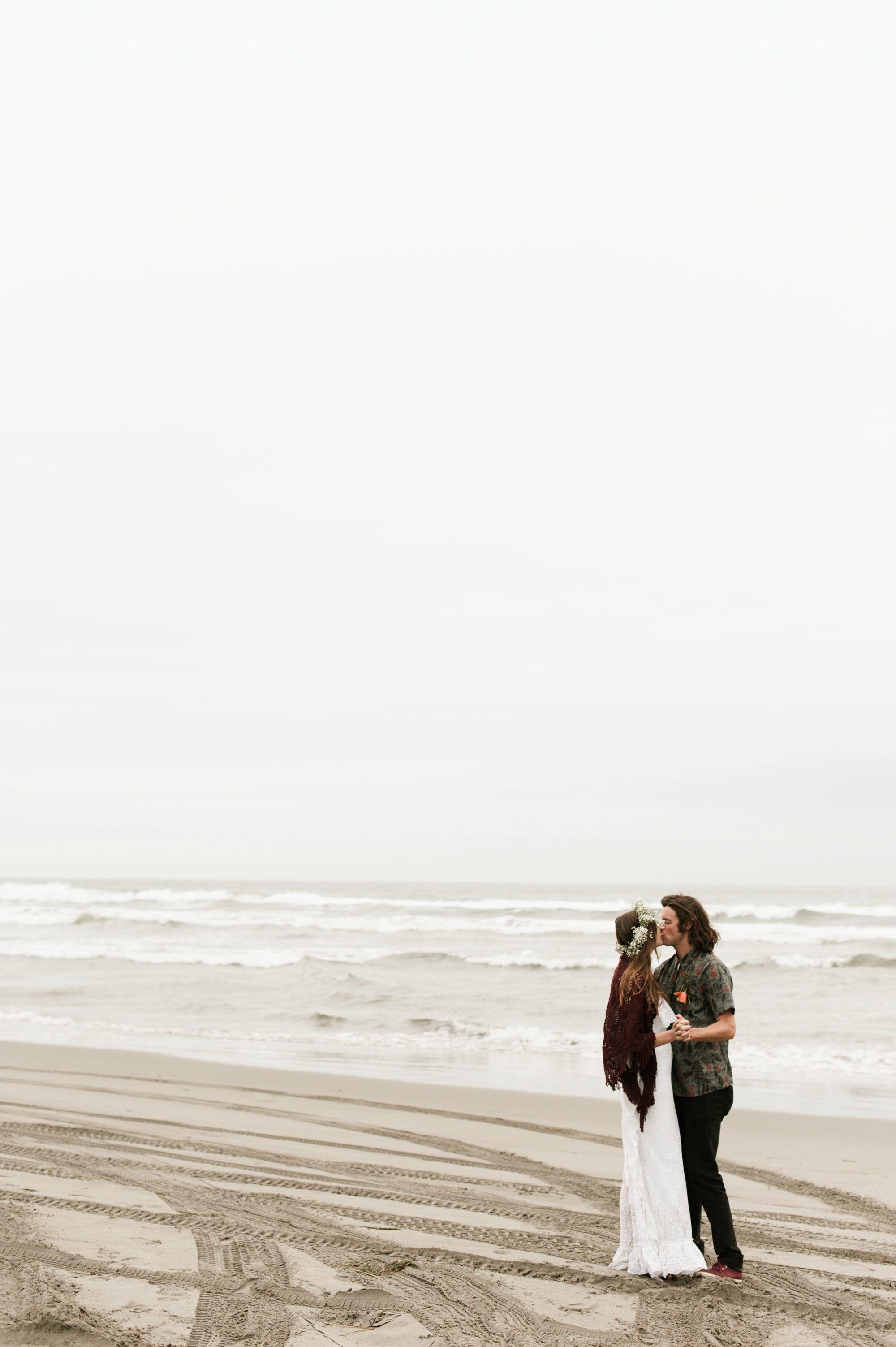 The newlyweds sneak a smooch on a deserted beach. By Sou'Wester wedding photographer Briana Morrison
