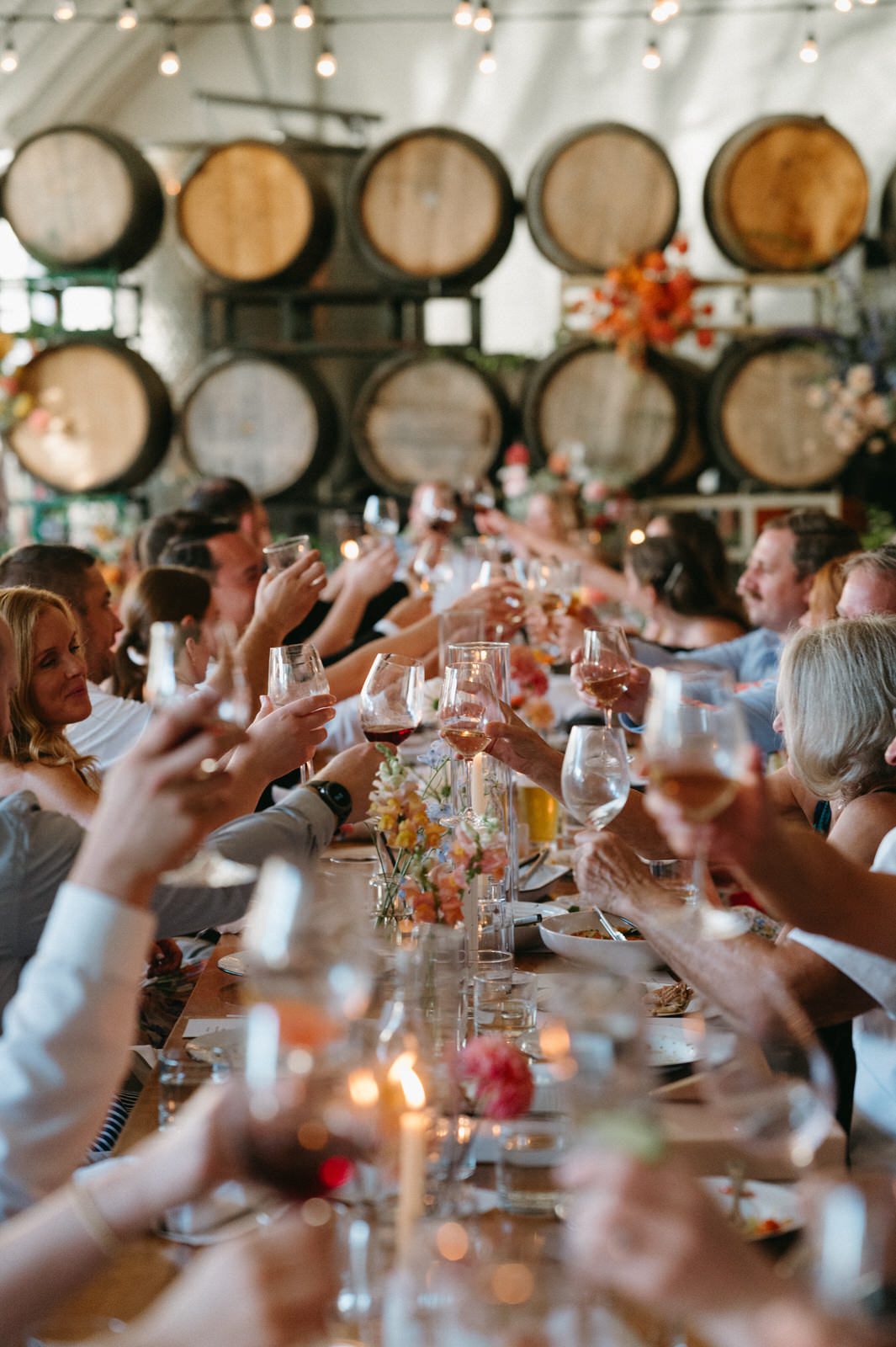 Wedding guests cheer a toast with wine glasses at Coopers Hall. Photographed by Portland wedding photographer, Briana Morrison.