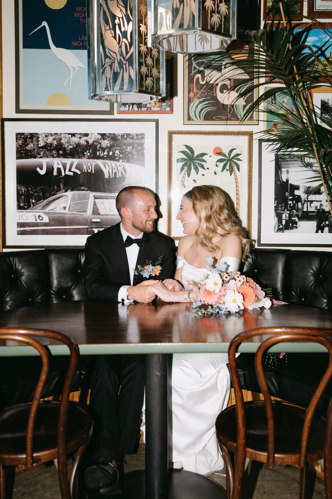 A flash portrait of a bride and groom looking at each other while sitting inside Hey Love. Photographed by Portland wedding photographer, Briana Morrison.