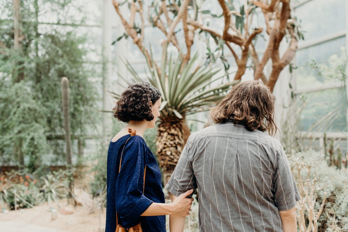 A couple admire cactus in Brooklyn Botanic Garden during their Brooklyn NY engagement session.