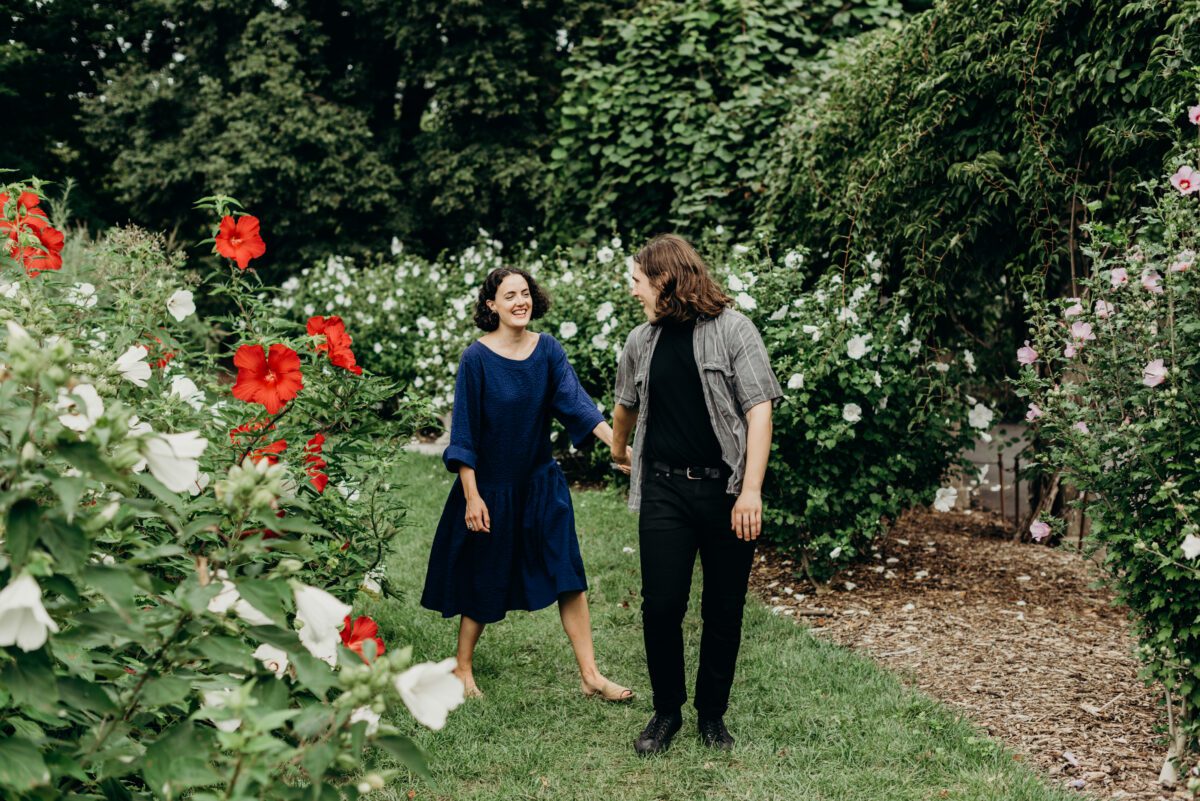 A young couple walks through the Prospect Park rose garden for their Brooklyn NY engagement portraits.