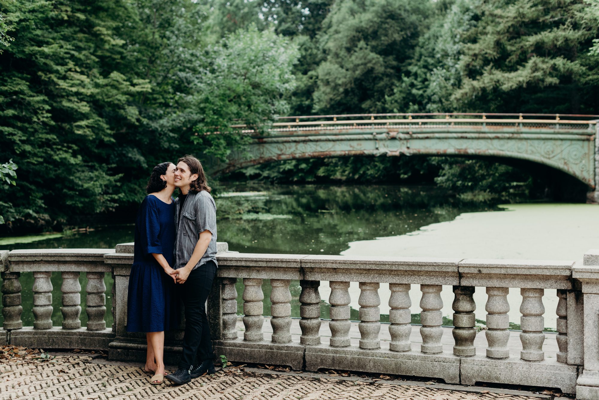 Cute couple posing for engagement photos at the Boathouse in Prospect Park, Brooklyn. Photos by Briana Morrison