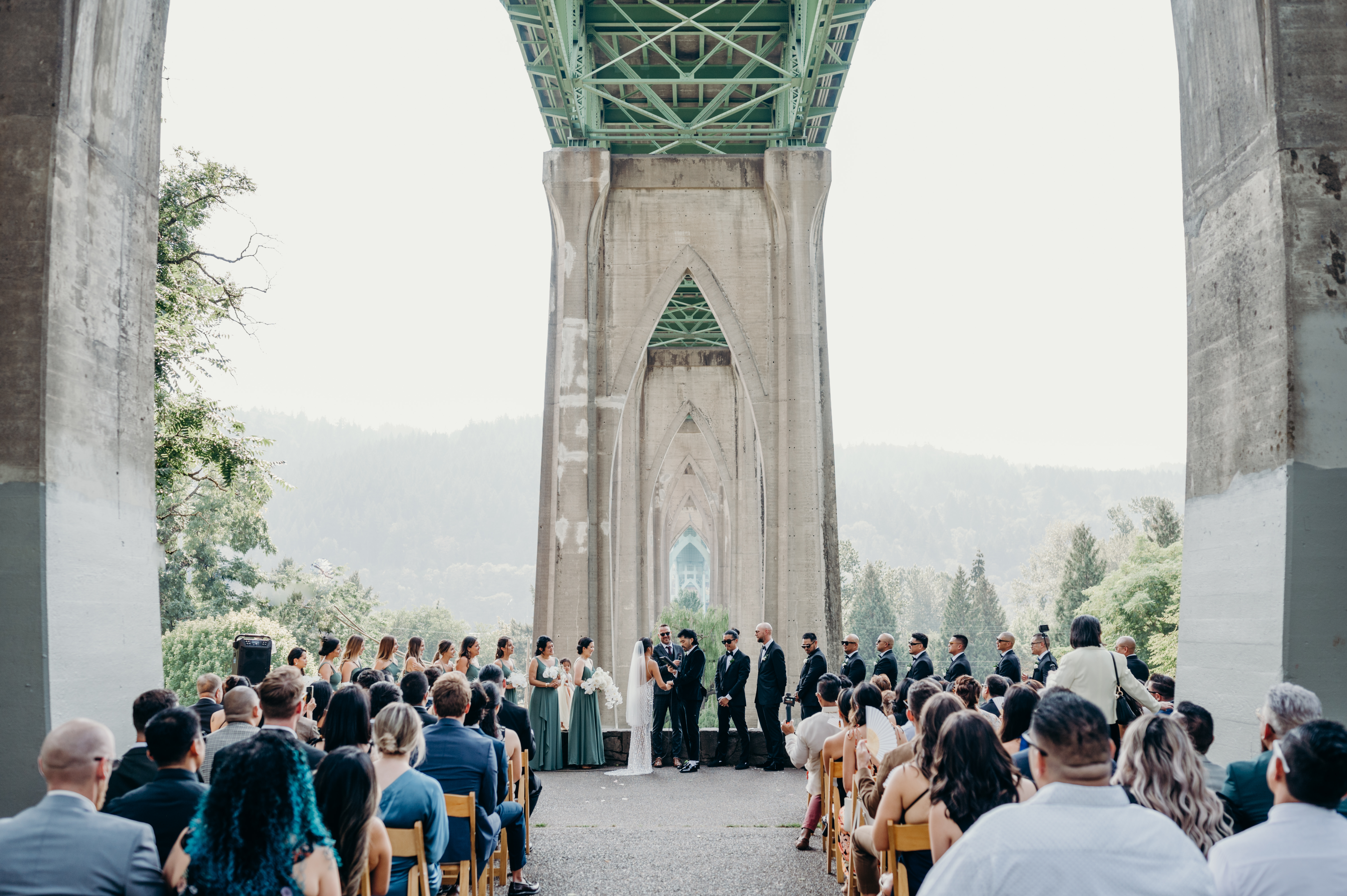 A couple gets married in outdoor Portland wedding venue Cathedral Park under the bridge