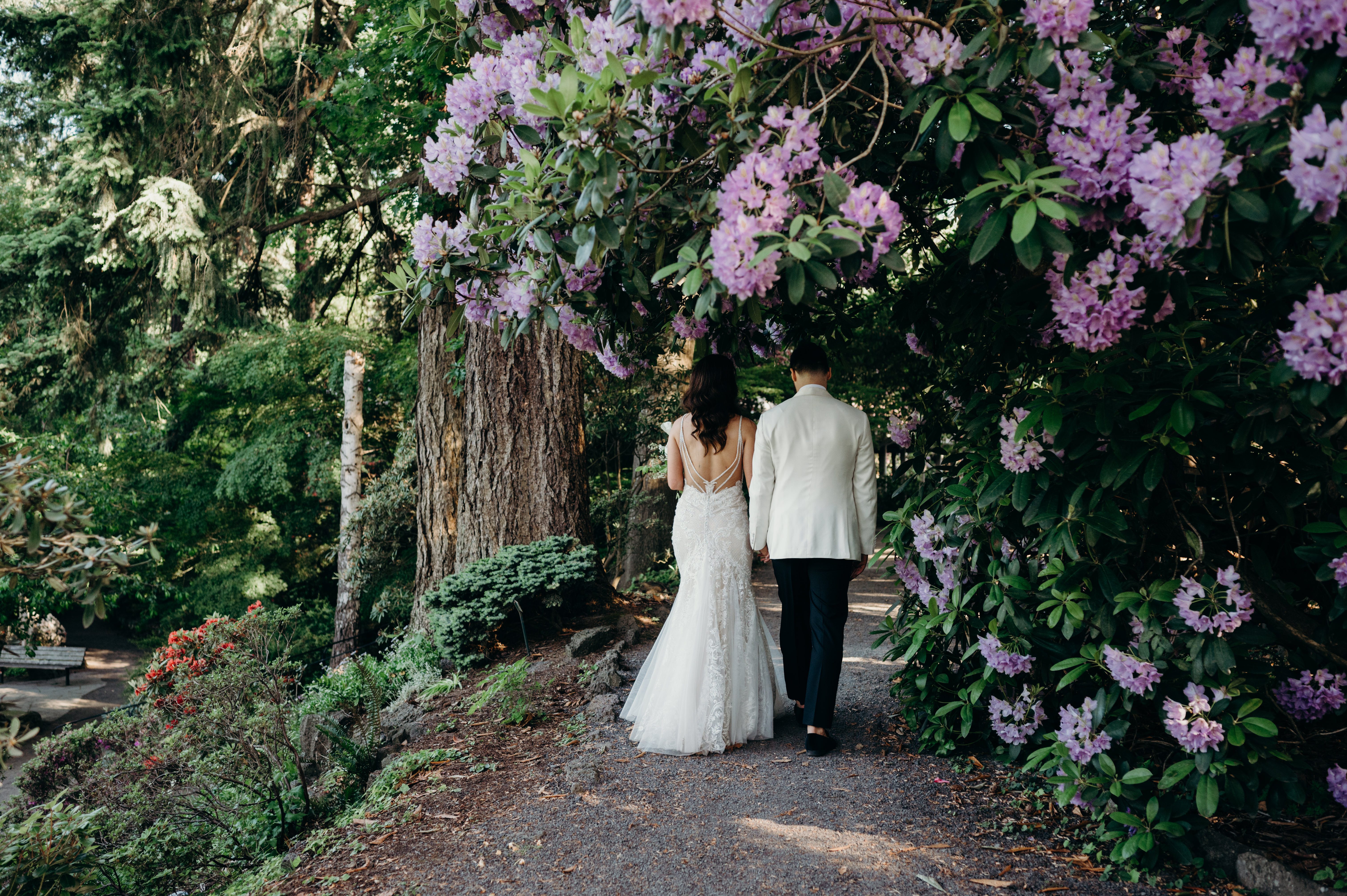 bride and groom stroll through their wedding venue Crystal Springs Rhododendron Gardens
