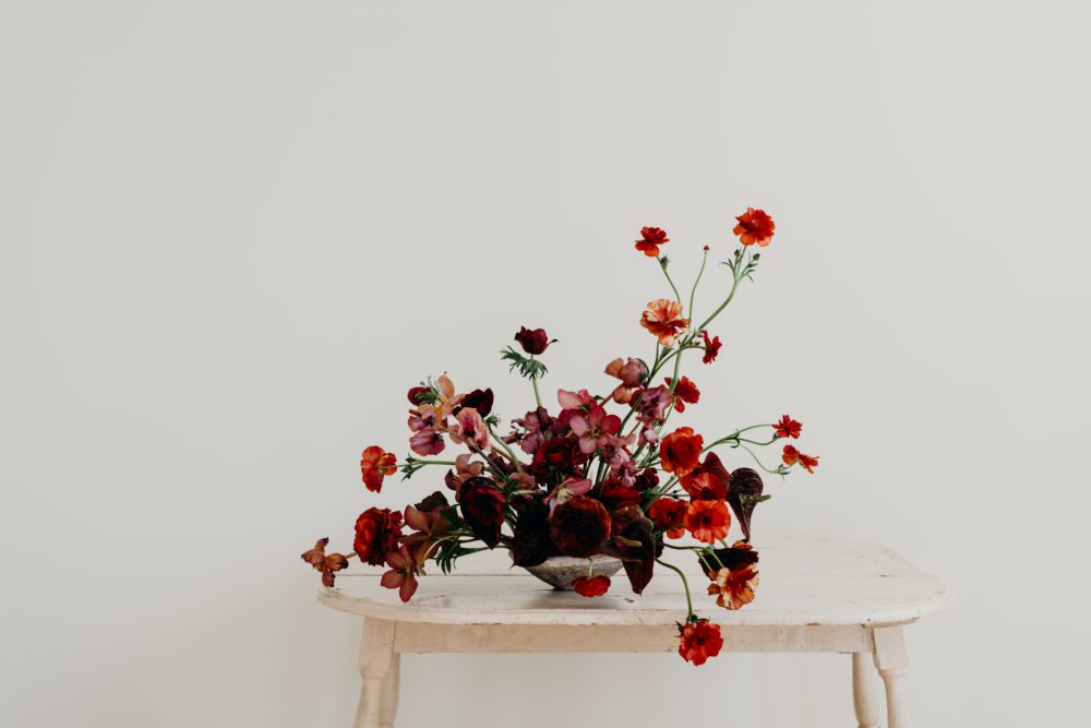 A beautiful rich red floral arrangement by Britlyn Simone of Metal and Moss.