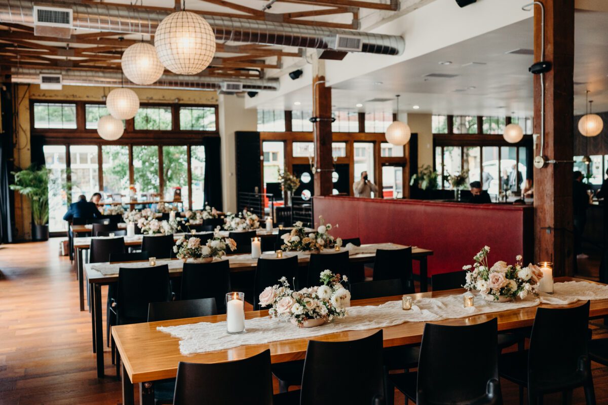 Hunt & Gather Events - an indoor wedding venue in Portland - pictured with florals and candles set on the dining tables ready for wedding guests to fill.