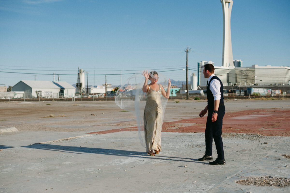 Bride plays with her veil and smiles at her new husband captured by Las Vegas elopement photographer Briana Morrison