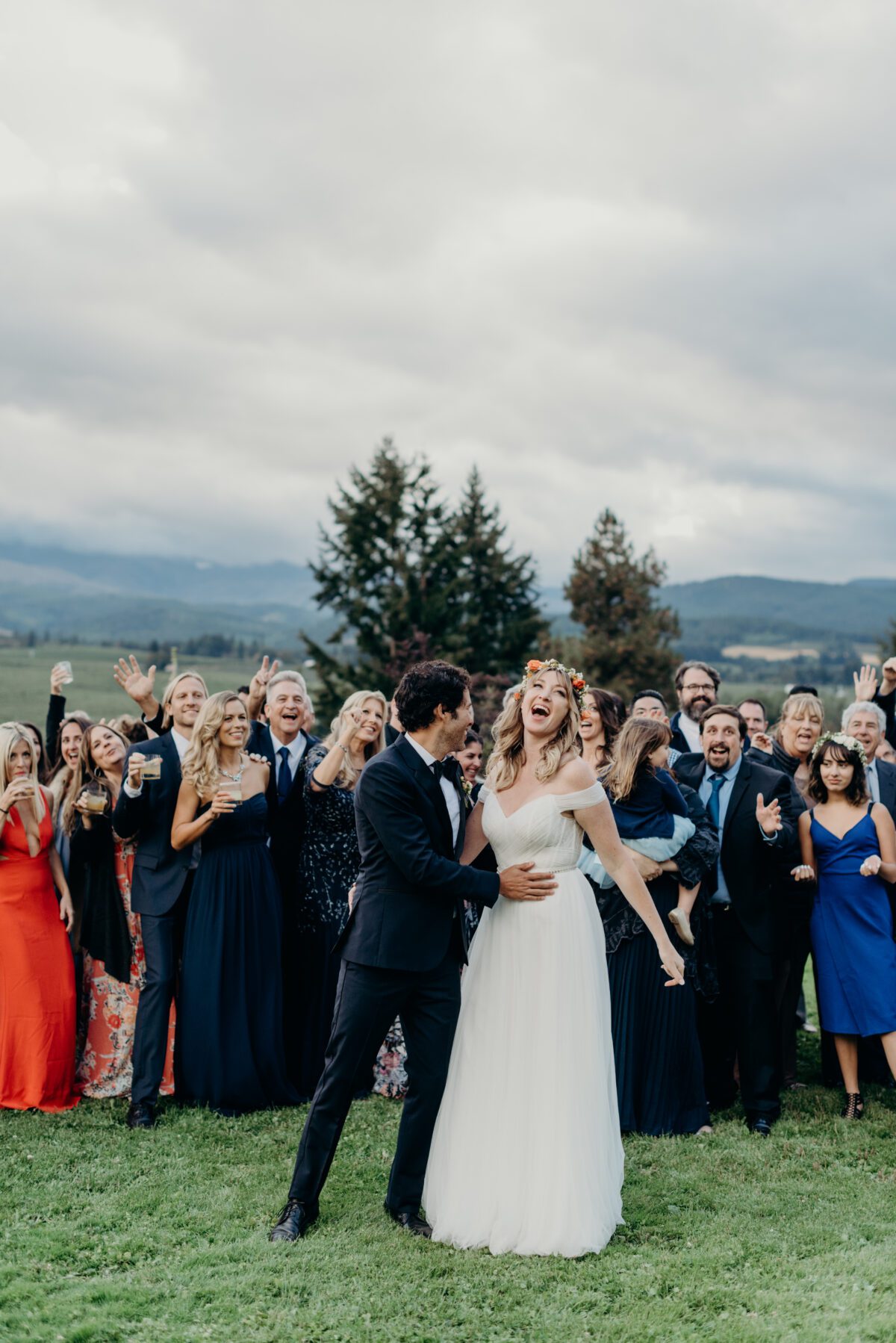 A fun and expressive portrait of a bride and groom and their full guest list