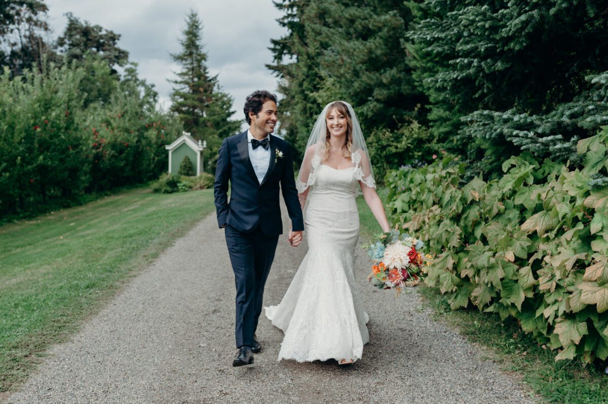 Beautiful outdoor portrait of a bride and groom walking through the garden path at Mt Hood Organic Farms