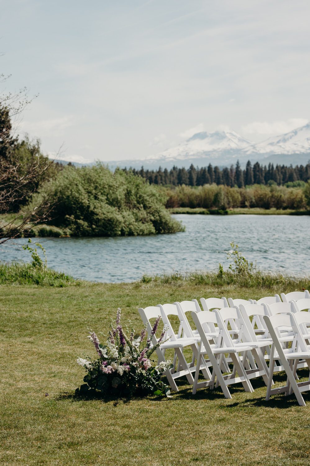 Ceremony chairs and flowers with a lake and mountains behind them at Black Butte Ranch.