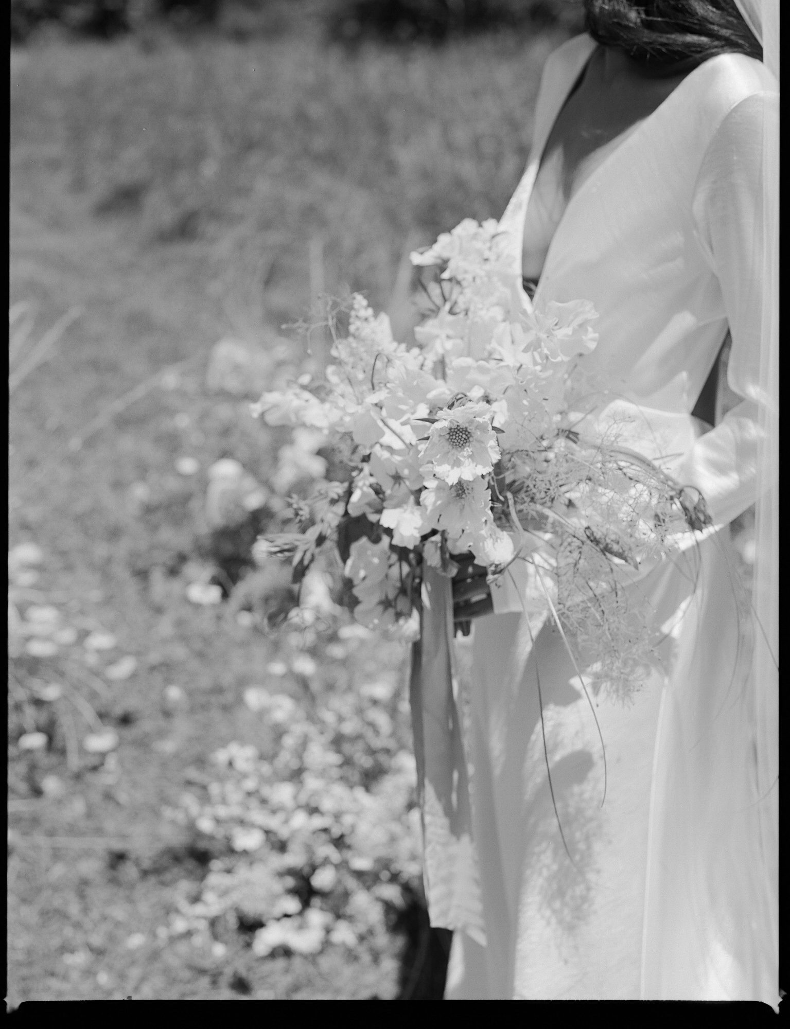 Black and white film photograph of a bride and her wedding bouquet by Portland wedding photographer, Briana Morrison