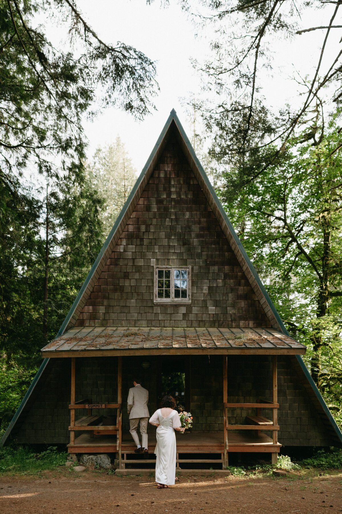 A bride and groom walk into an A Frame cabin at Camp Namanu in Sandy, Oregon